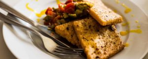 De délicieuses panelle et leur couleur brun doré, servies avec une salade d'avocats et de tomates